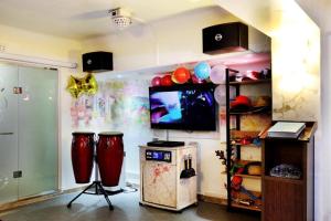 een woonkamer met een tv en 2 drums bij Amant Hotel in Goyang