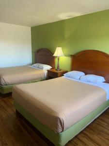2 camas en una habitación de hotel con paredes verdes en Relax Inn & Suites en Mattoon