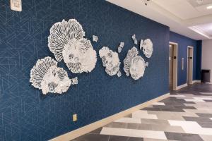 a wall with white flowers on a blue wall at DoubleTree by Hilton Tinton Falls-Eatontown in Tinton Falls