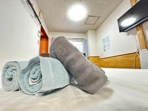 2 paires de chaussettes assises au-dessus d'un lit dans l'établissement NEAR Sapporo St & Hokkaido University Cozy studio sanwa101, à Sapporo