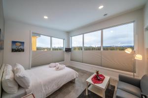 een slaapkamer met een bed, een bank en ramen bij Northern Lights Resort & Spa in Whitehorse