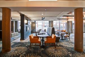 a lobby with tables and chairs and a fireplace at Homewood Suites by Hilton Gaithersburg/Washington, DC North in Gaithersburg