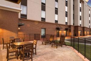 un patio avec des tables et des chaises en bois et un bâtiment dans l'établissement Hampton Inn & Suites - Lavonia, GA, à Lavonia