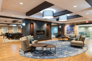a lobby with chairs and tables and a fireplace at Homewood Suites by Hilton Grand Rapids Downtown in Grand Rapids