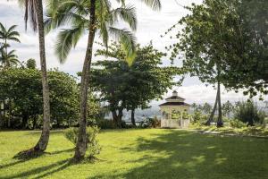 um gazebo no meio de um parque com palmeiras em Grand Naniloa Hotel, a Doubletree by Hilton em Hilo
