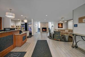 a hotel lobby with a fireplace and a bar at Homewood Suites by Hilton Eatontown in Eatontown