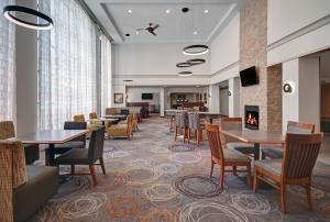 ein Esszimmer mit Tischen, Stühlen und einem Kamin in der Unterkunft Homewood Suites by Hilton Eatontown in Eatontown