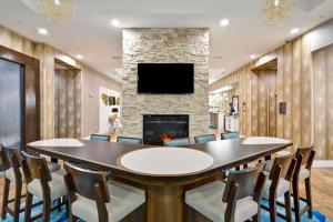 a conference room with a table and chairs and a fireplace at Homewood Suites By Hilton Galveston in Galveston