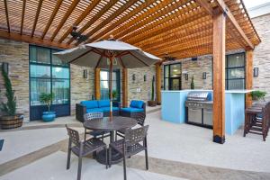 un patio con sombrilla, mesa y sillas en Homewood Suites By Hilton Galveston en Galveston