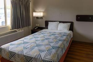 um quarto de hotel com uma cama com um edredão colorido em Motel 6-Lufkin, TX em Lufkin