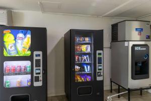Hay dos máquinas expendedoras junto a una máquina de bebidas. en Motel 6-Lufkin, TX en Lufkin