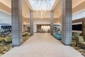 a lobby with columns and couches and a chandelier at Hilton Garden Inn Grand Rapids East in Grand Rapids