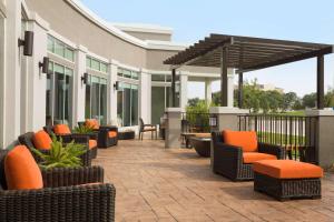 an outdoor patio with chairs and tables and an umbrella at Hilton Garden Inn Houston-Baytown in Baytown