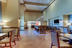 a restaurant with tables and chairs and a bar at Hampton Inn & Suites - Hartsville, SC in Hartsville