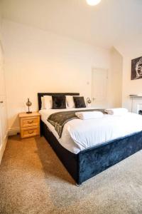 a bedroom with a large bed and a night stand at Fitzwilliam House -3 Bed House in Redcar