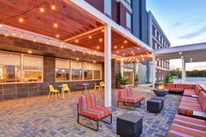 a patio with colorful chairs and tables on a building at Home2 Suites by Hilton La Porte in La Porte