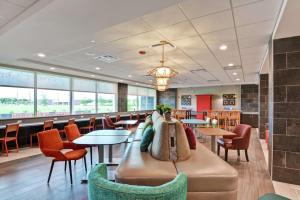 a restaurant with tables and chairs and a couch at Home2 Suites by Hilton La Porte in La Porte