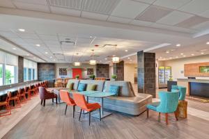 a lobby with a couch and chairs and a bar at Home2 Suites by Hilton La Porte in La Porte