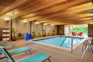 a pool in a house with wooden ceilings at Home2 Suites By Hilton Frederick in Frederick