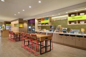 a restaurant with tables and chairs in a cafeteria at Home2 Suites By Hilton Frederick in Frederick
