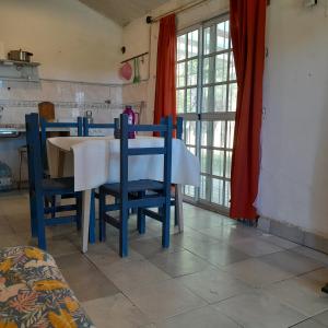 uma cozinha com mesa e cadeiras num quarto em Los Aloes, Casa de campo em Las Toninas