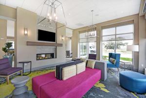 a living room with a couch and a fireplace at Hilton Garden Inn Houston Hobby Airport in Houston