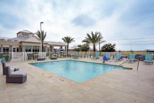 a large swimming pool with chairs at Hilton Garden Inn Houston Hobby Airport in Houston