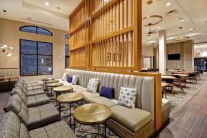 um átrio do hotel com um sofá, mesas e cadeiras em Homewood Suites By Hilton Greenville Downtown em Greenville