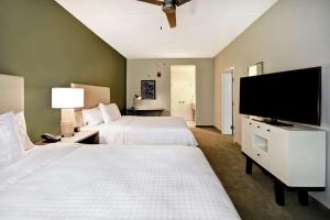 a hotel room with two beds and a flat screen tv at Homewood Suites By Hilton Greenville Downtown in Greenville