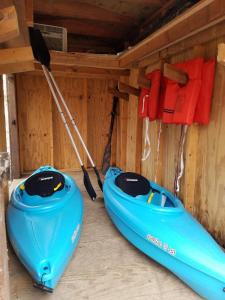 dos kayaks sentados en una habitación con una pared en Outdoorsy AFrame Set Back On Acreage on Hamlin Lake-Hot Tub-Kayaks-Firepit, en Free Soil