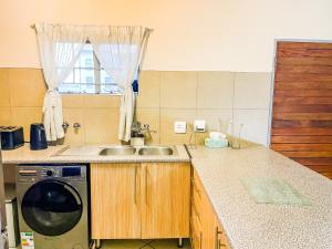 a kitchen with a sink and a washing machine at Melody in Midrand
