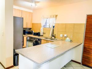 eine Küche mit einer Arbeitsplatte und einem Kühlschrank in der Unterkunft Melody in Midrand