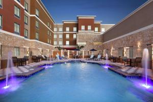 a hotel pool with fountains in front of a building at Homewood Suites By Hilton Harlingen in Harlingen
