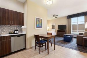 a room with a table and a kitchen and a living room at Homewood Suites By Hilton Harlingen in Harlingen
