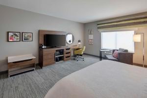 a hotel room with a bed and a flat screen tv at Hampton Inn & Suites D'Iberville Biloxi in Biloxi