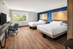 Habitación de hotel con 2 camas, escritorio y silla en Tru By Hilton Ft Lauderdale Airport en Dania Beach