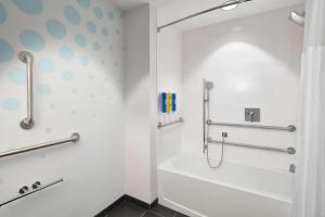 a bathroom with a tub and a shower stall at Tru By Hilton Ft Lauderdale Airport in Dania Beach +23 photos