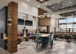 a restaurant with tables and chairs and a fireplace at Homewood Suites By Hilton Jackson Fondren Medical District in Jackson
