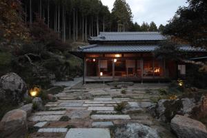 una casa con un camino de piedra delante de ella en うだ薬湯の宿やたきや, en Uda