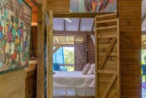 a bedroom with a bed in a wooden house at Sizo Treehouse Cottage in Roseau