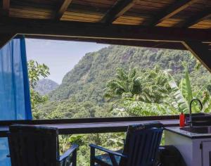 a room with a view of a mountain at Sizo Treehouse Cottage in Roseau