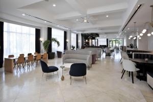 eine Lobby mit einem Wartezimmer mit Tischen und Stühlen in der Unterkunft Hotel Dello Ft Lauderdale Airport, Tapestry Collection by Hilton in Dania Beach