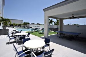 un patio con tavoli e sedie accanto alla piscina di Hotel Dello Ft Lauderdale Airport, Tapestry Collection by Hilton a Dania Beach