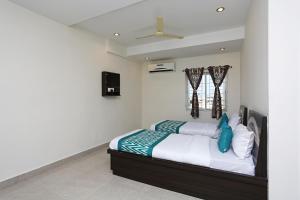a bedroom with a bed and a ceiling fan at OYO Flagship Hotel DS Grand Inn in Lingampalli
