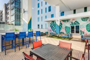 a patio with a table and chairs and a building at SERENA Hotel Aventura Miami, Tapestry Collection by Hilton in Aventura