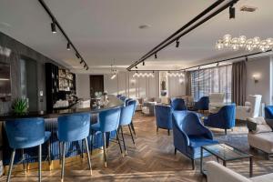 - un bar dans une pièce avec des chaises bleues dans l'établissement Hotel Imperial Plovdiv, a member of Radisson Individuals, à Plovdiv