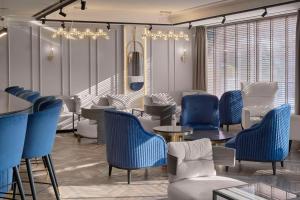 - une salle d'attente avec des tables et des chaises bleues dans l'établissement Hotel Imperial Plovdiv, a member of Radisson Individuals, à Plovdiv