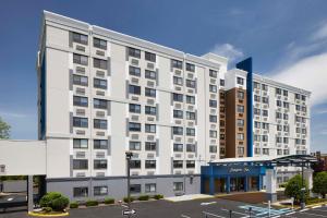 un gran edificio blanco con aparcamiento en Hampton Inn Newark Airport, en Newark