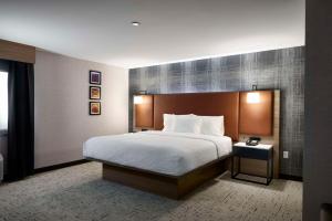 a hotel room with a bed and a night stand at Hampton Inn Newark Airport in Newark