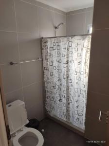 a bathroom with a toilet and a shower curtain at Departamentos Don Lucio in La Paz